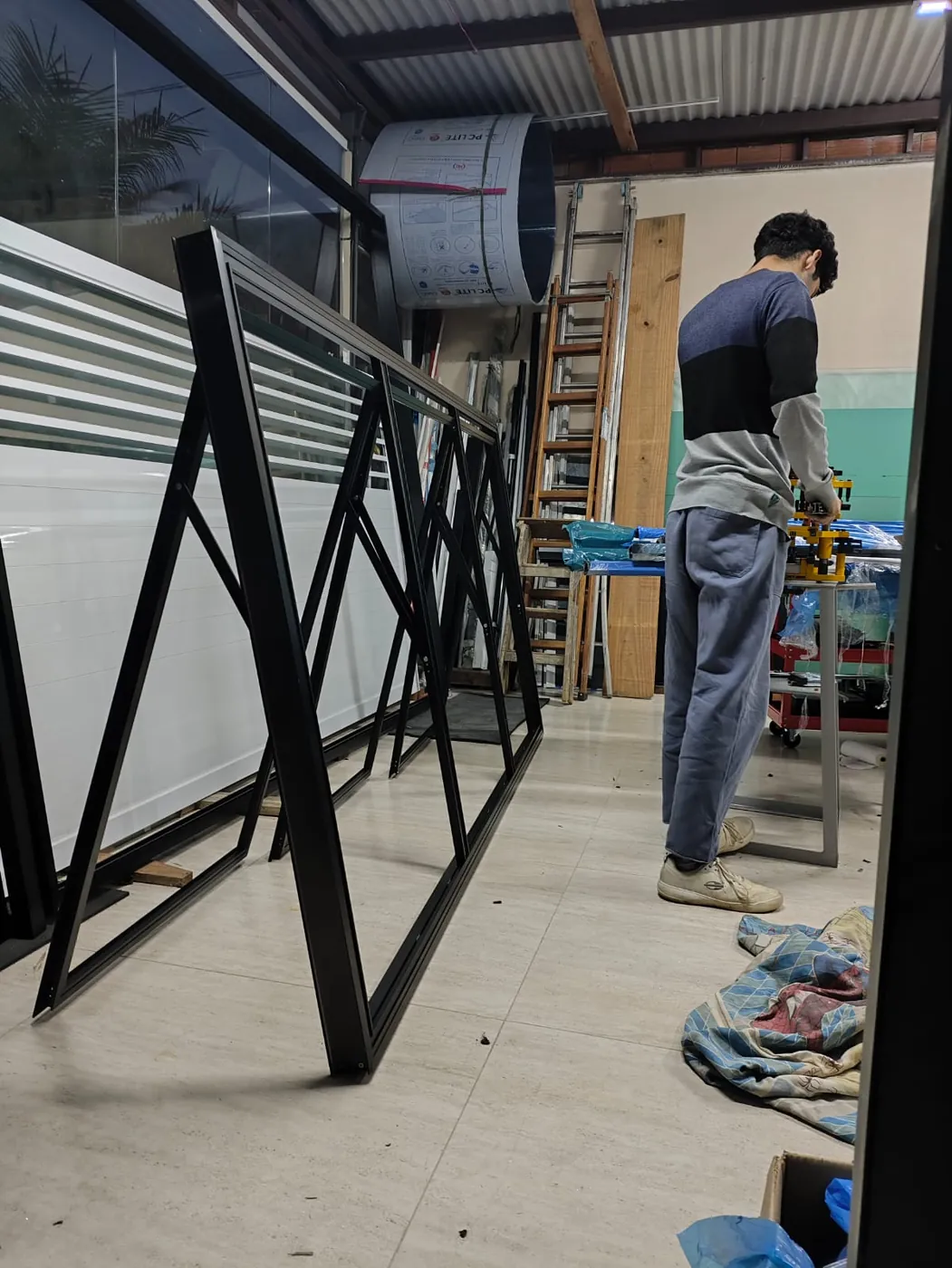 Esquadrias de alumínio preto em montagem na bancada da sala