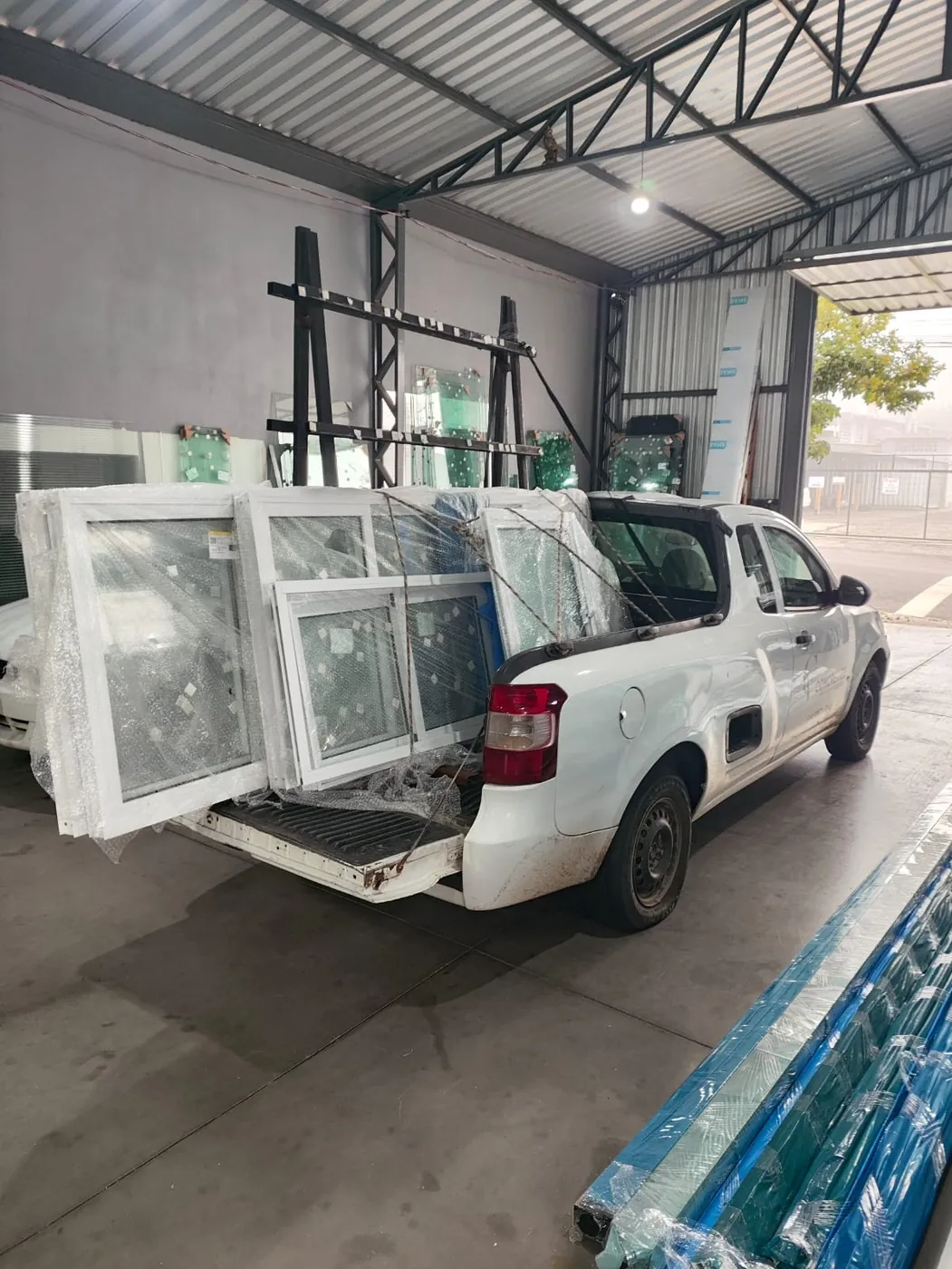 Picape carregada de janelas de alumínio branco, prontas para a entrega