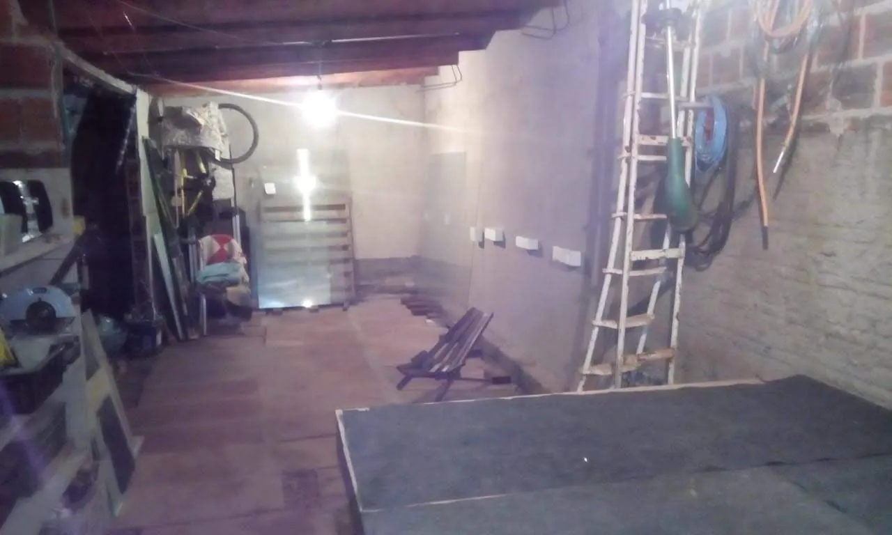A garagem nos fundos de casa onde a Concretize começou, com bancada, ferramentas e chapas de vidro