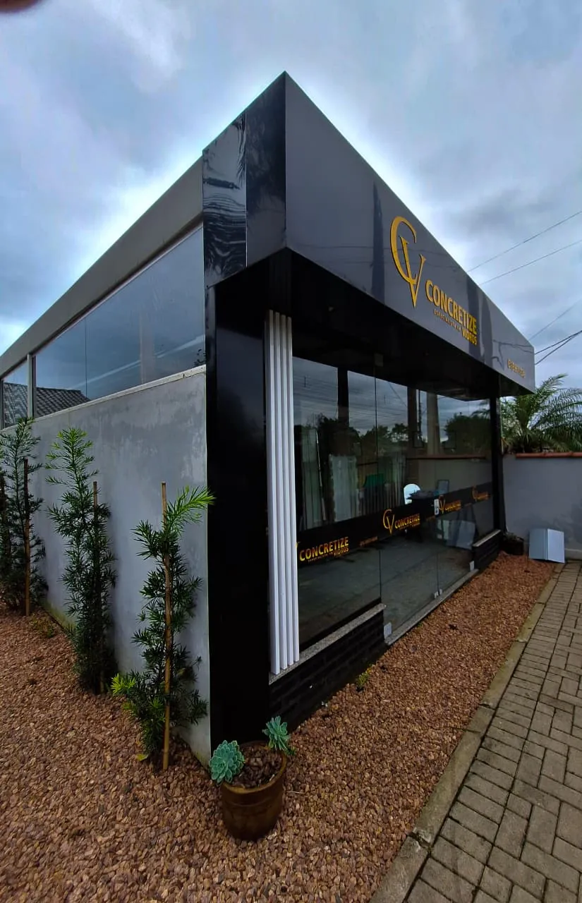A primeira sala pronta, com fachada preta, vidro e a marca em dourado