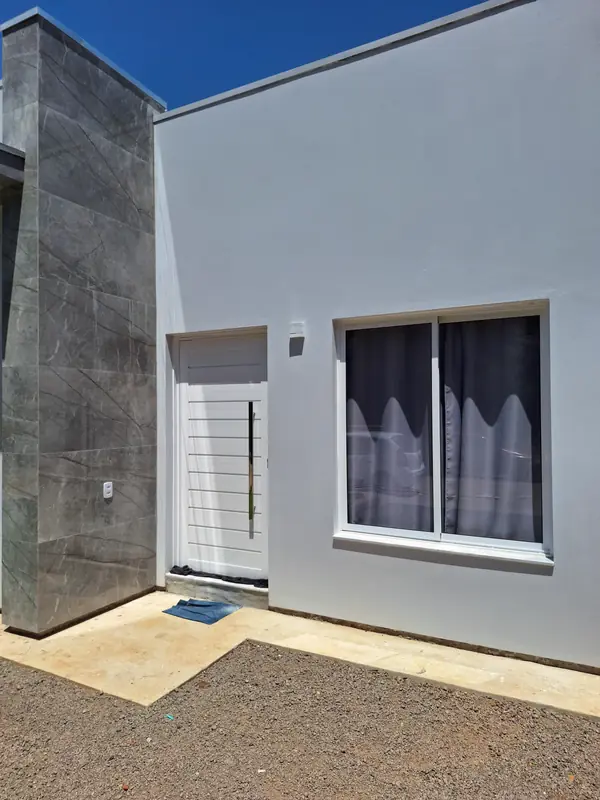 Fachada de casa com porta e janela em alumínio branco