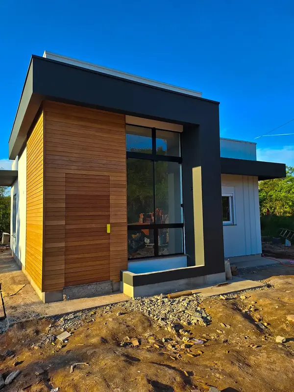 Casa moderna com revestimento de madeira e esquadrias de alumínio preto