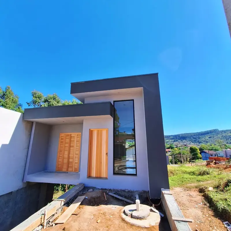 Casa cinza com janela alta de alumínio preto, vale ao fundo