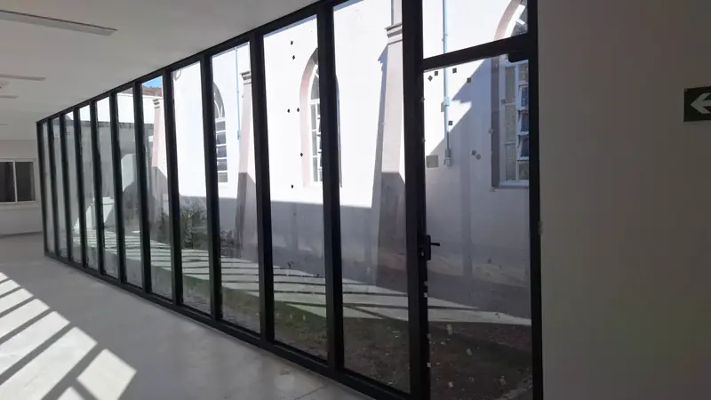 Hospital Bom Jesus: corredor com fechamento em vidro e perfis pretos
