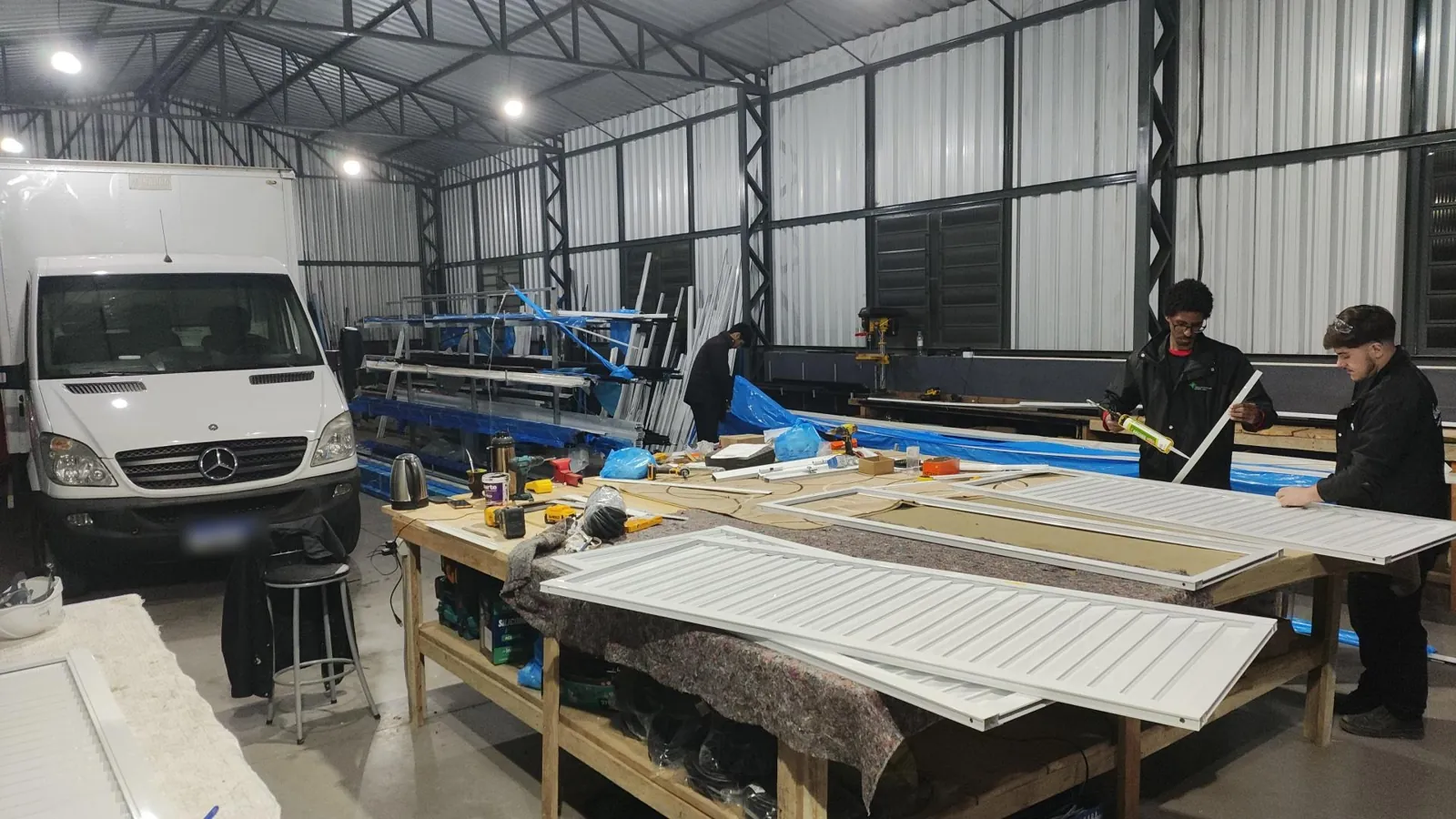 Produção de venezianas de alumínio na bancada do pavilhão
